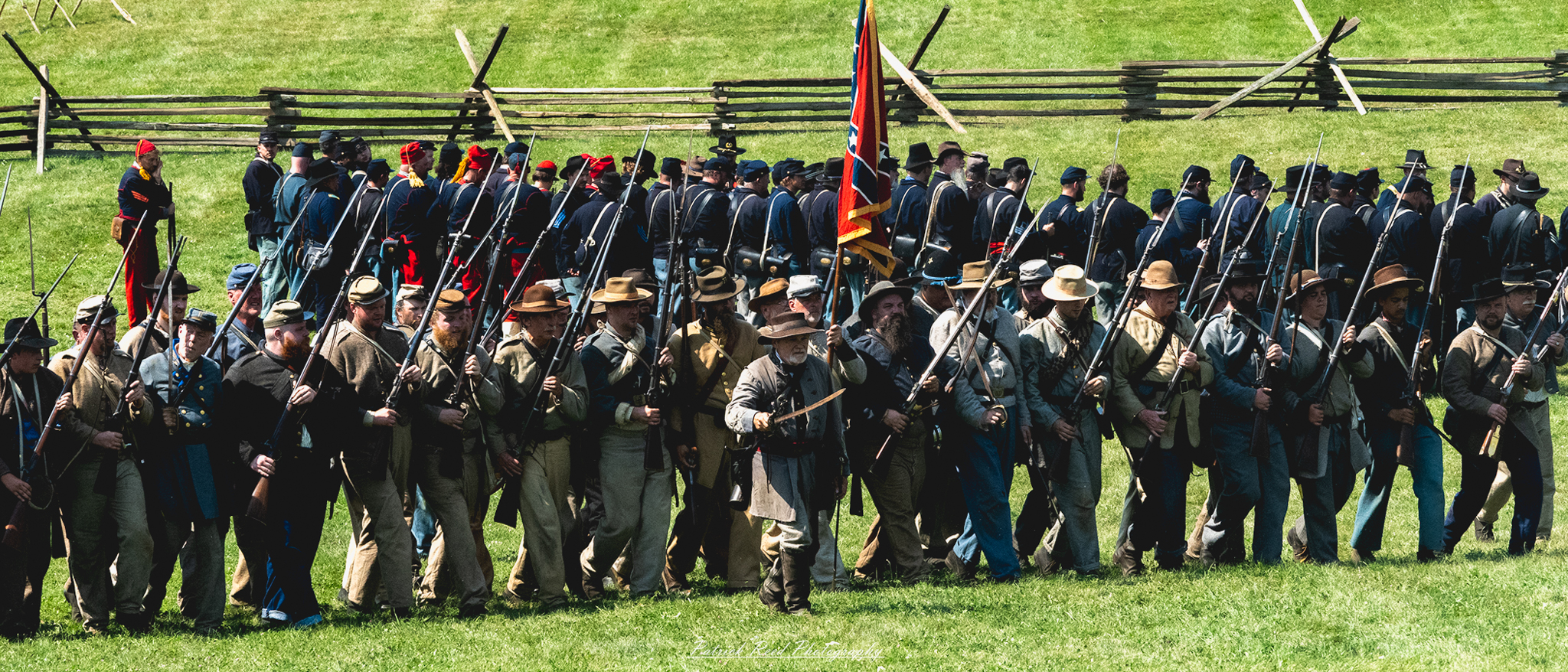 A row of Confederate soldiers standing in formation, dressed in their gray uniforms with weapons at the ready. Their expressions are serious and focused, reflecting the discipline and camaraderie among the troops as they prepare for battle in a Civil War setting.